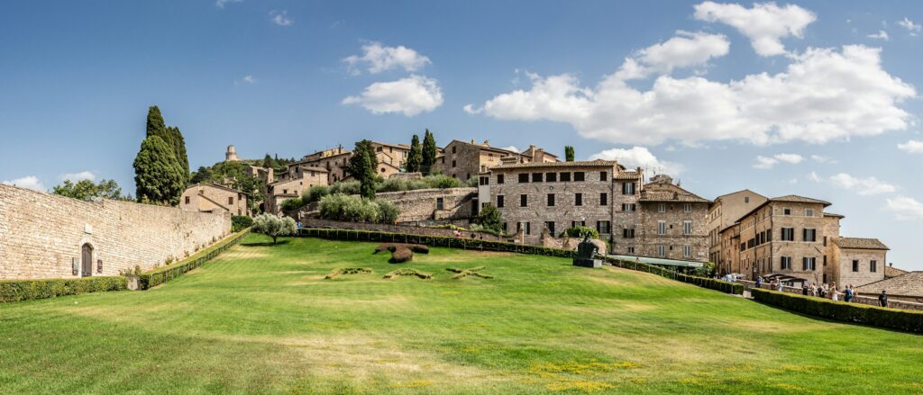 Colle di Assisi con ulivi, cipressi e case medievali in pietra